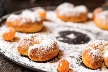 Small sweet croissants and candy sprinkled with powder sugar