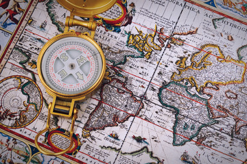 Compass and vintage map on a wooden table.