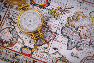 Compass and vintage map on a wooden table.