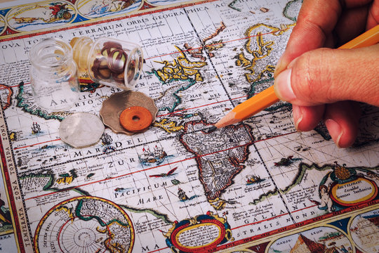 Pencil, compass and vintage map on a wooden table.
