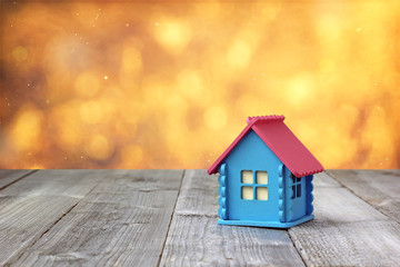 A small wooden house with blue walls and pink roof.