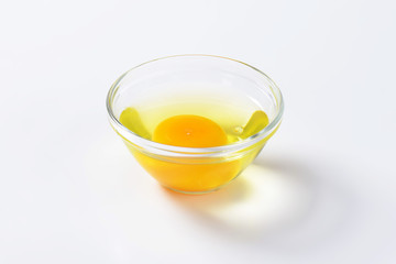 Egg white and yolk in glass bowl
