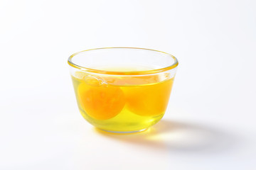 Egg whites and yolks in glass bowl
