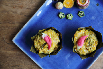 steamed fish with curry paste on wood background