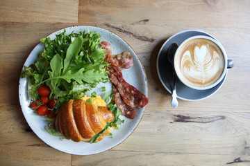 croissant with egg and bacon on wood background