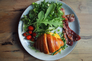 croissant with egg and bacon on wood background