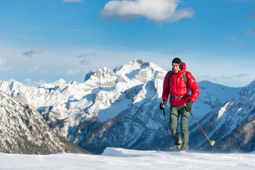 Fototapeta na wymiar Man walking in a winter landscape whit snowshoes