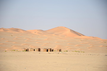 Fototapeta na wymiar Small huts in sand dunes in desert, Oman