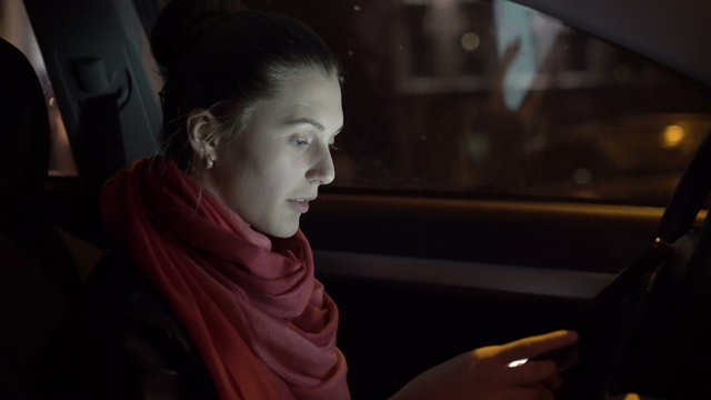 Profile of girl sitting in the car and using a tablet, 4K
