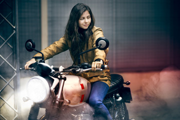 Fototapeta na wymiar Girl makes a burnout riding an old fashioned motorbike