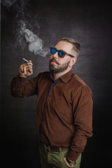 Bearded man in sunglasses smoking a cigarette