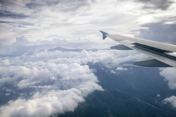 Fototapeta premium Wing of an airplane flying above the clouds