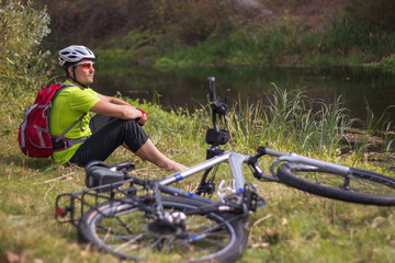 Man walking with a mountain bike in the countryside.