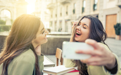 Two young women taking selfie with smart phone