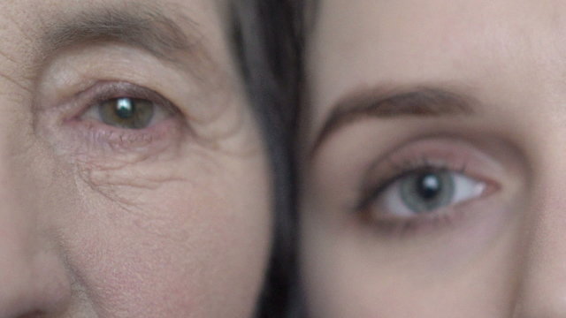 Close up eyes of grandmother and granddaughter. Cuddling. Slowly