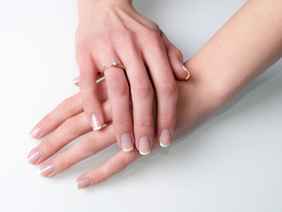 Woman hands with engagement ring on white