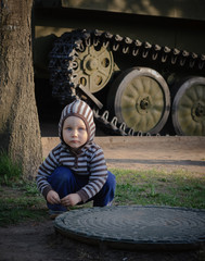 Boy plays on the background of the tank