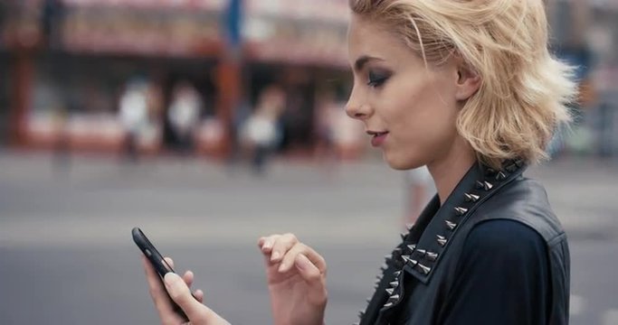 Slow Motion Portrait of happy beautiful caucasian punk woman using smart phone
