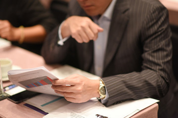 Close-up Of Businessman Holding Document At Desk
