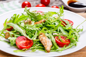 low-calories salad with chicken breast, arugula and cherry tomat