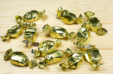 Wrapped toffees on wooden background
