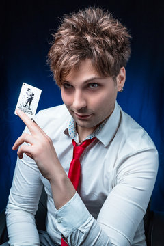 man illusionist with joker card in hand 