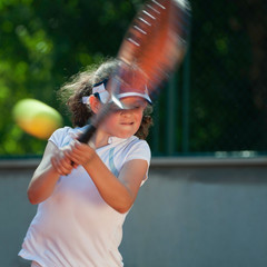 Little tennis champion hitting tennis ball