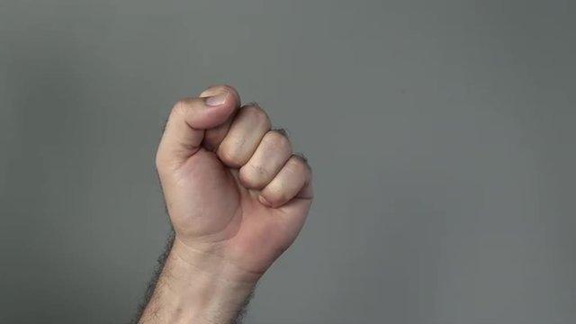 Man hand show fist on a grey background. Concepts and ideas with copy space