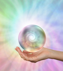 Magical Floating Orb with rainbow spiral energy - female hand outstretched with a hypnotic orb...