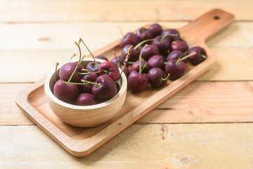 Cherries on wooden table with water drops macro background