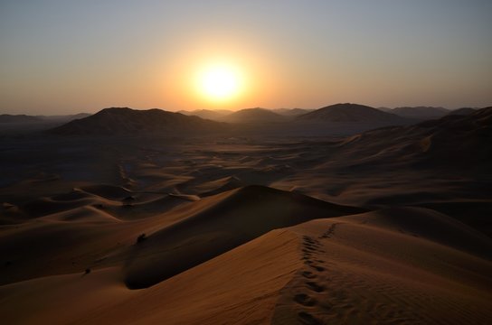 Desert sun, tracks and sand dunes