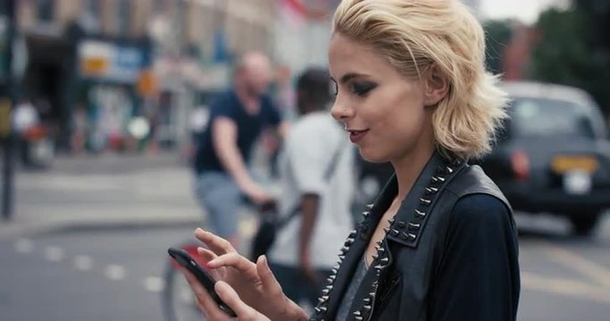 Slow Motion Portrait of happy beautiful caucasian punk woman using smart phone