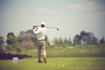 Golfers hit sweeping golf course in the summer.Vintage color