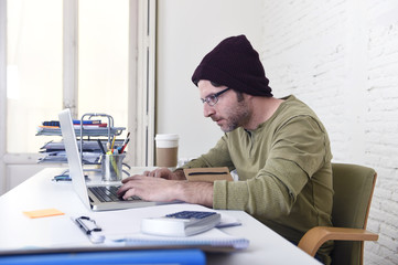 young attractive hipster businessman working from his home office as freelancer self employed...