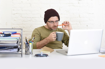 Obraz na płótnie Canvas young attractive hipster businessman working from his home office as freelancer self employed business model