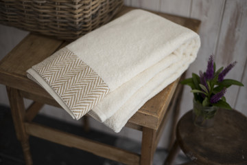 Fototapeta na wymiar Folded White Towel with Brown Herringbone Design in Low Light