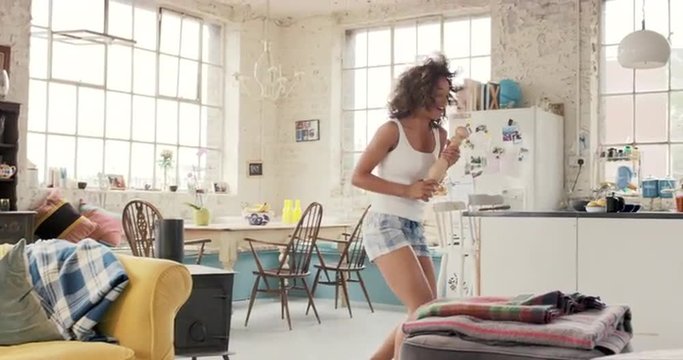 Happy Curly Haired  Girl Dancing Wearing Pyjamas At Home In Kitchen 