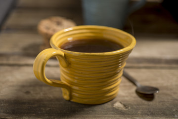 Yellow Cup Containing Coffee or Tea Beside Spoon