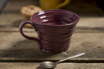 Empty Brown Teacup Beside Spoon with Cookies in the Background