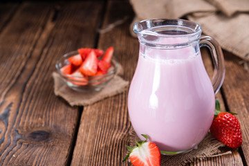 Milk (Strawberry flavoured) on wooden background