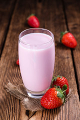 Milk (Strawberry flavoured) on wooden background