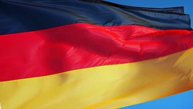 Germany flag waving in slow motion against clean blue sky, seamlessly looped, close up, isolated on alpha channel with black and white luminance matte, perfect for film, news, digital composition