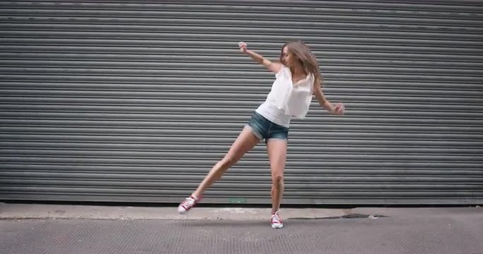 Contemporary funky caucasian woman street dancer dancing freestyle in the city