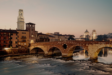 Fototapeta premium Ponte Pietra and river side apartment buildings in Verona. Verona has been awarded World Heritage Site status by UNESCO because of its urban structure and architecture.