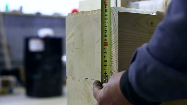 Worker measures height of profiled bar, close-up