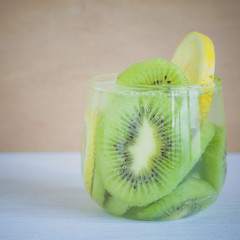 Fototapeta na wymiar Kiwi fruit and lemon slice with soda water make detox water recipe