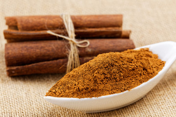 Cinnamon sticks with cinnamon powder on wooden background, Selective focus