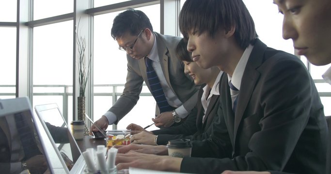 Motivated Japanese work team sliding shot 4K