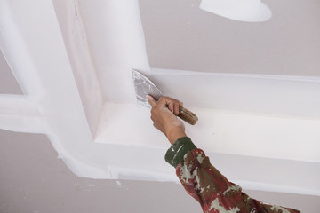 hand of worker using gypsum plaster ceiling joints - obrazy, fototapety, plakaty