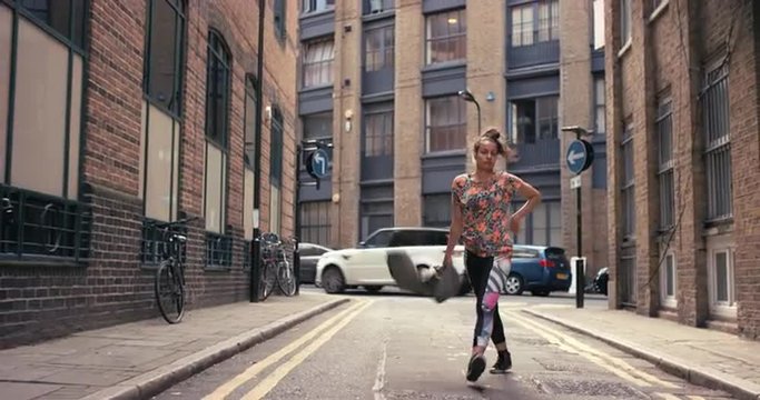 Contemporary funky mixed race woman street dancer dancing freestyle in the city